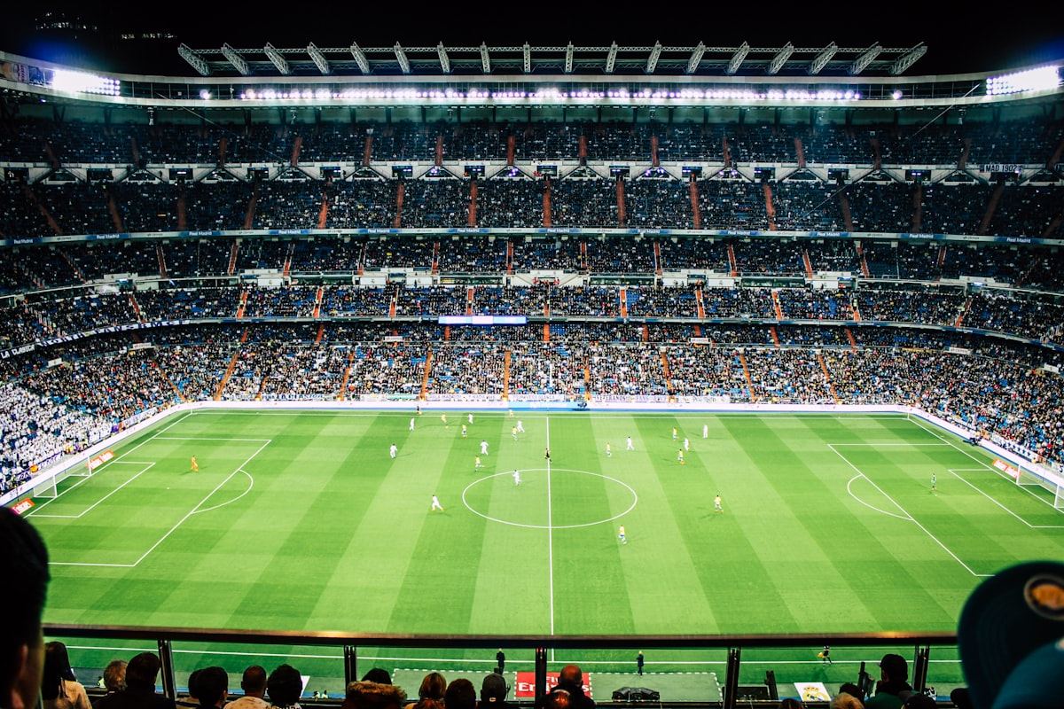 Stadion sepak bola besar dengan lampu sorot terang